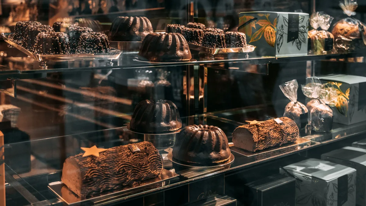Vitrine de confeitaria com bolos e doces de chocolate expostos lado a lado