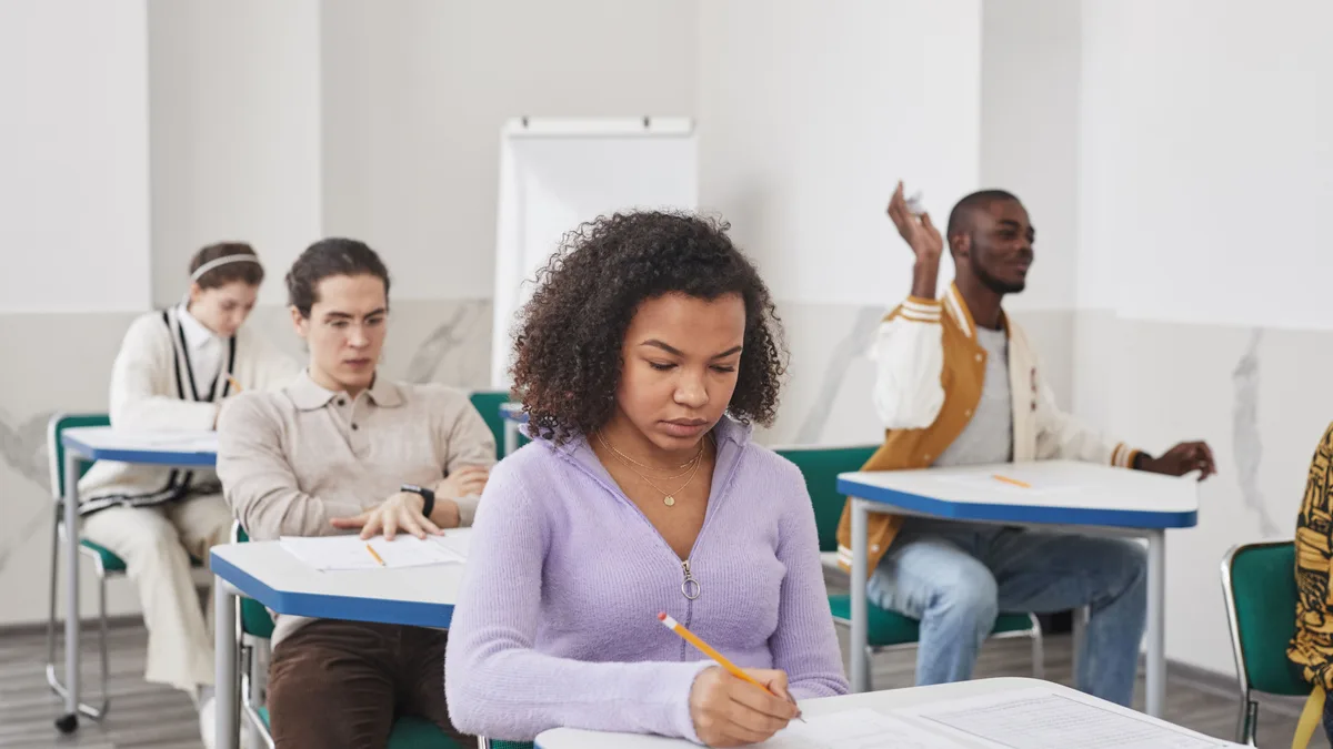 Grupo de estudantes concentrados durante prova em sala de aula