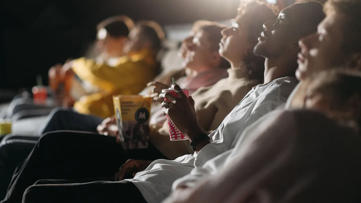 Grupo de amigos assistindo a um filme no cinema, em noite de sessão compartilhada