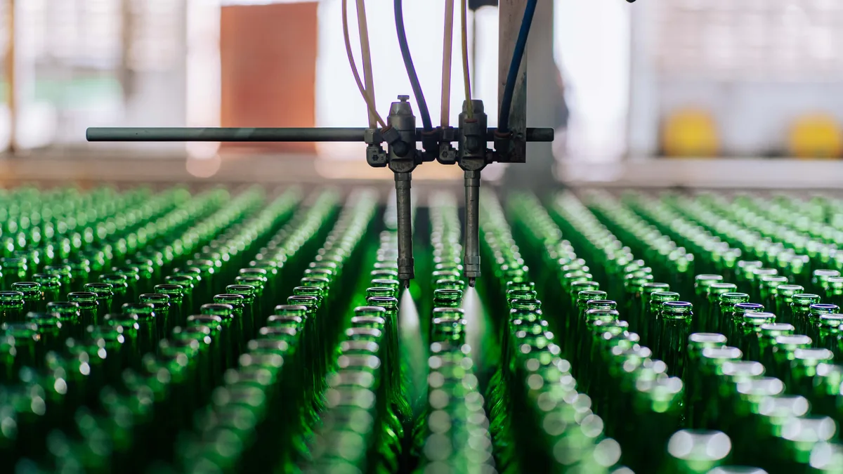 Garrafas de vidro alinhadas numa linha de produção automatizada de fábrica